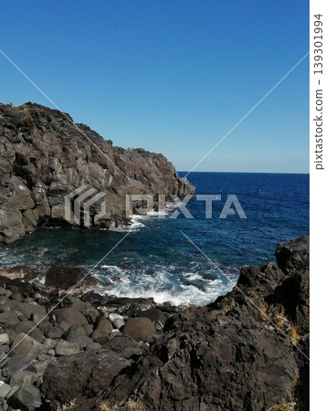 Rough white waves crashing against the sheer cliff face and the deep blue sea. Rough white waves crashing against the sheer cliff face and the deep blue sea. 139301994