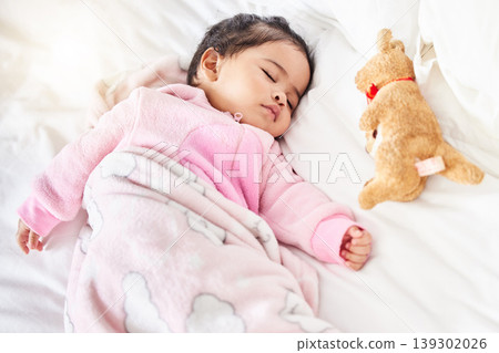 Baby, sleeping and girl in bed with teddy bear, animal and peace in home with blanket and comfort. Child, rest and sleep in morning, nap and routine for health, wellness and calm face of infant Baby, sleeping and girl in bed with teddy bear, animal and peace in home with blanket and comfort. Child, rest and sleep in morning, nap and routine for health, wellness and calm face of infant 139302026