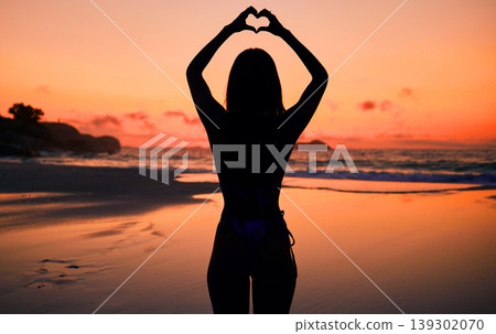 Woman, silhouette and sunset by water with heart hands for love, care and kindness with sign, summer and body. Girl, person and beach with symbol, emoji or icon on vacation, ocean or outdoor at dusk Woman, silhouette and sunset by water with heart hands for love, care and kindness with sign, summer and body. Girl, person and beach with symbol, emoji or icon on vacation, ocean or outdoor at dusk 139302070