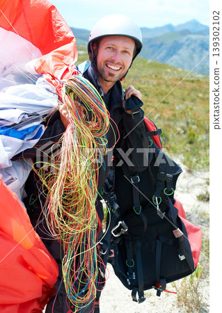 Paragliding, parachute or man in nature for portrait, happy or strings for training for flight preparation. Athlete, face or smile for fitness for outdoor wellness, helmet or equipment in countryside 139302102