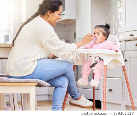 Mother, feed and child food in chair for baby development, nutrition meal or dinner snack. Kid, woman and eating breakfast hungry for parent care or love for lunch together, vitamin diet in kitchen 139302127