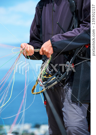 Paragliding, rope and sport with hands of person in nature for flight, travel or vacation. Safety gear, holiday and trip with closeup of man and strings in outdoors for action, parasailing and cord Paragliding, rope and sport with hands of person in nature for flight, travel or vacation. Safety gear, holiday and trip with closeup of man and strings in outdoors for action, parasailing and cord 139302137