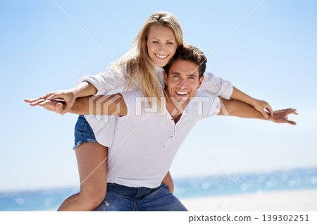 Couple, beach and happy for piggy back in portrait, vacation or freedom in summer sunshine for bonding. Man, woman and plane game with smile, care or love by sand, waves or play on holiday in Napoli Couple, beach and happy for piggy back in portrait, vacation or freedom in summer sunshine for bonding. Man, woman and plane game with smile, care or love by sand, waves or play on holiday in Napoli 139302251