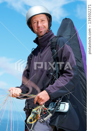 Paragliding, parachute and man with portrait in nature in preparation, exercise or health support. Athlete, face or fitness for happy outdoor with safety harness, helmet or equipment in countryside 139302271