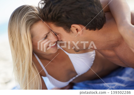 Beach, couple smile and embrace with love, support and care on holiday by the sea and ocean. Romance, bonding and kiss with young people together on vacation adventure on sand about to kiss on a date 139302286