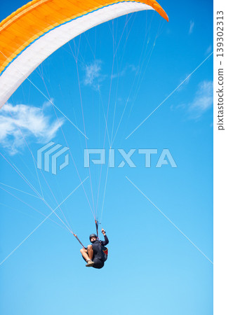 Man, paragliding and blue sky adventure fun in clouds for explore city, outdoor courage or fearless athlete. Male person, parachute and mockup space or safety equipment for landing, flying in nature 139302313