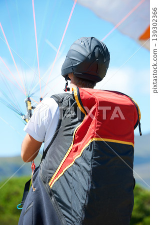 Man, parachute or paragliding launch in nature, exercise or healthy adventure for extreme sport. Person, strings or training for outdoor fitness for wellness, helmet or safety gear by blue sky Man, parachute or paragliding launch in nature, exercise or healthy adventure for extreme sport. Person, strings or training for outdoor fitness for wellness, helmet or safety gear by blue sky 139302366