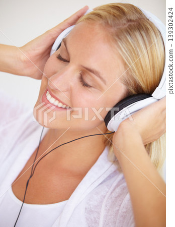 Woman, eyes closed and smile with headphones for listening in closeup for music, podcast or radio. Person, calm or peaceful expression on face for audio, song or streaming service in home on internet Woman, eyes closed and smile with headphones for listening in closeup for music, podcast or radio. Person, calm or peaceful expression on face for audio, song or streaming service in home on internet 139302424