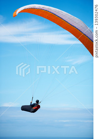 Man, paragliding and blue sky adventure parachute in clouds for explore city, outdoor courage or fearless athlete. Male person, safety equipment for landing flying in nature sport, activity in wind 139302476