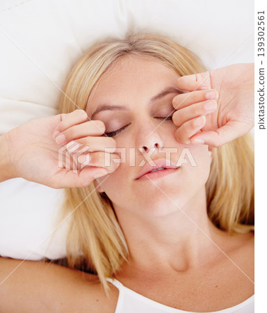 Woman, eyes closed and hands for waking up in bedroom for sleepy, tiredness or fatigue in morning. Person, burnout or bad dream with exhaustion, stress or insomnia with peace for resting in closeup Woman, eyes closed and hands for waking up in bedroom for sleepy, tiredness or fatigue in morning. Person, burnout or bad dream with exhaustion, stress or insomnia with peace for resting in closeup 139302561