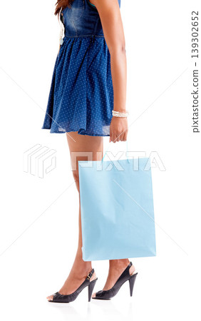 Woman, hand and legs with shopping bag in fashion or dress isolated against a white studio background. Female person, shopper or model walking with gift, present or sale discount on clothing purchase Woman, hand and legs with shopping bag in fashion or dress isolated against a white studio background. Female person, shopper or model walking with gift, present or sale discount on clothing purchase 139302652