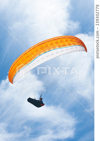 Man, parachute and paragliding in blue sky for flight, freedom and courage with extreme sport. Athlete, glide and fearless in outdoor fitness for adventure, health and sports by ocean with mountain Man, parachute and paragliding in blue sky for flight, freedom and courage with extreme sport. Athlete, glide and fearless in outdoor fitness for adventure, health and sports by ocean with mountain 139302778