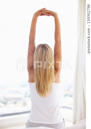 Woman, arms and stretching in bedroom with back view for wellness, health or waking up in morning. Person, open curtain and sunlight for sleep, rest or relaxing with bright flare on window in home Woman, arms and stretching in bedroom with back view for wellness, health or waking up in morning. Person, open curtain and sunlight for sleep, rest or relaxing with bright flare on window in home 139302796