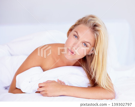 Woman, face and looking with portrait for lying on bed for relaxing, rest or peace in home. Female person, think and pose in serious expression for wake up, pillow and alone with cool, trendy or hair 139302797