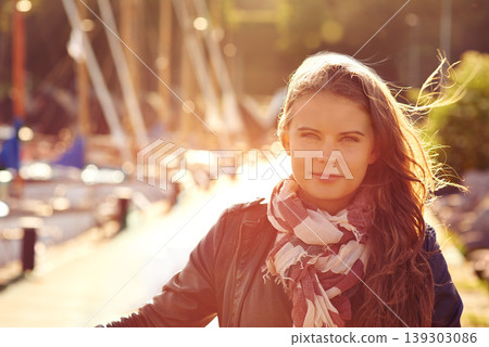 Portrait, fashion in summer and a woman in the harbor for travel, freedom or adventure with flare. Face, wind and style with a confident young person outdoor in a dock or shipyard for trendy clothing Portrait, fashion in summer and a woman in the harbor for travel, freedom or adventure with flare. Face, wind and style with a confident young person outdoor in a dock or shipyard for trendy clothing 139303086