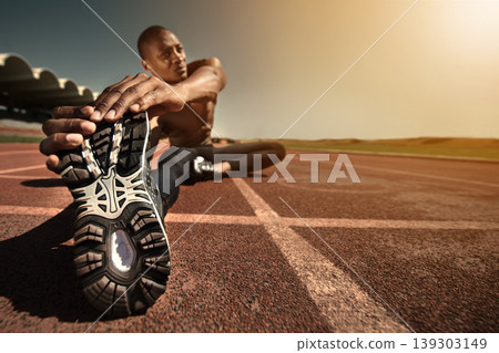Man, shoes and stretching leg on ground, sunset and fitness for health, sports and performance. Black male person, athlete and warmup on track, workout and commitment or ready, train and outdoors 139303149
