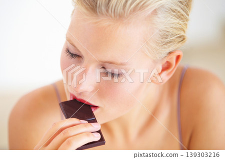 Relax woman, face and eating dark chocolate for antioxidants benefits, morning wellness or stress relief food. Diet cheat meal, eyes closed and person enjoy sugar craving, cacao bar or sweets slab Relax woman, face and eating dark chocolate for antioxidants benefits, morning wellness or stress relief food. Diet cheat meal, eyes closed and person enjoy sugar craving, cacao bar or sweets slab 139303216
