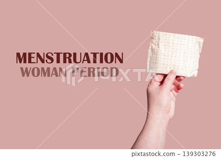 Classic menstrual pads in woman hand. Menstrual cycle and suffering from menstrual pain. Female period and intimate hygiene Classic menstrual pads in woman hand. Menstrual cycle and suffering from menstrual pain. Female period and intimate hygiene 139303276