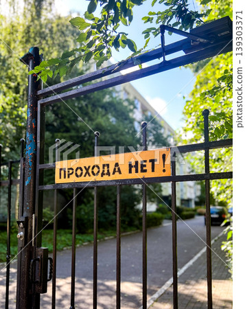 No entry sign on black metal gates. No entry on Russian language - Prohoda net. Access is prohibited No entry sign on black metal gates. No entry on Russian language - Prohoda net. Access is prohibited 139303371