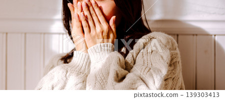 A woman hiding her face A woman hiding her face 139303413