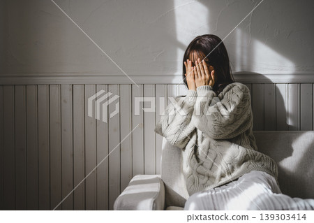 A woman hiding her face A woman hiding her face 139303414
