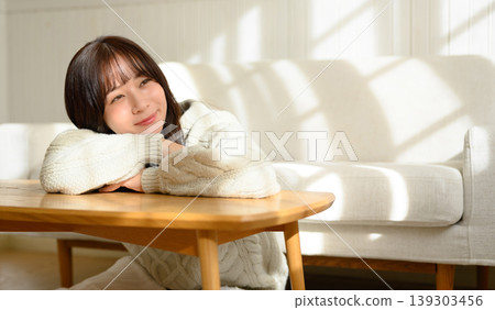 Woman relaxing in her room Woman relaxing in her room 139303456