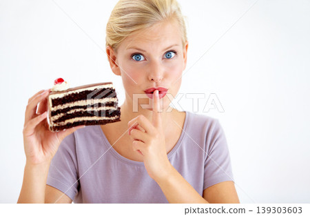 Secret, cake and young woman in a studio cheating on healthy, wellness or weight loss diet. Yummy, sweet and female person from Australia eating a chocolate dessert isolated by white background. Secret, cake and young woman in a studio cheating on healthy, wellness or weight loss diet. Yummy, sweet and female person from Australia eating a chocolate dessert isolated by white background. 139303603