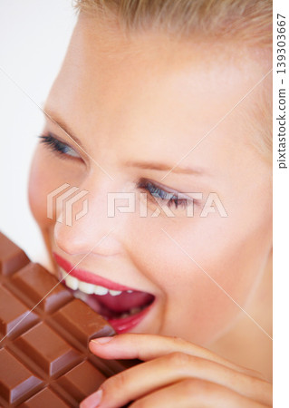 Studio face, woman and eating chocolate slab bar, delicious snack or unhealthy junk food, dessert or sugar candy. Wellness craving, beauty skin and person bite sweets isolated on white background Studio face, woman and eating chocolate slab bar, delicious snack or unhealthy junk food, dessert or sugar candy. Wellness craving, beauty skin and person bite sweets isolated on white background 139303667