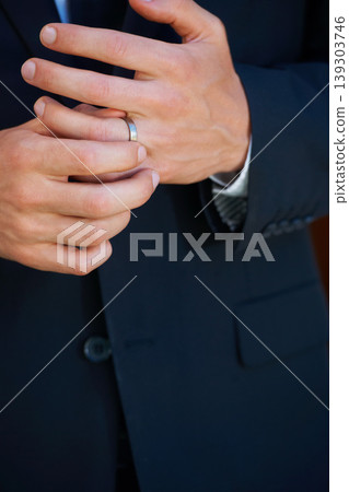 Groom, hand closeup and ring for marriage, ceremony or celebration in suit, fingers and event. Person, palm and metal jewelry for wedding, party or commitment to relationship, engagement or proposal 139303746