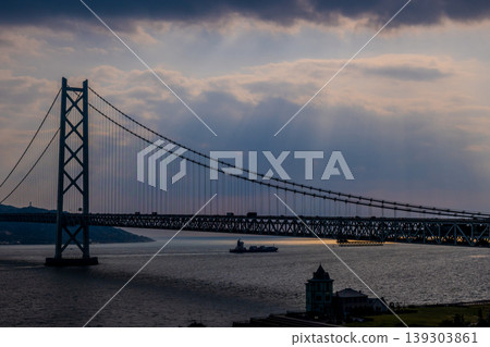 [Spectacular View] The Akashi Kaikyo Bridge at sunset, illuminated by the ships passing through the Akashi Strait and the sun's rays. 139303861