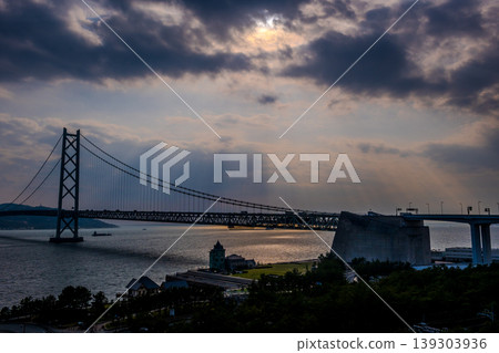 【戲劇性】暮色中,明石海峽大橋熠熠生輝,暮光穿透厚厚的雲層。 【戲劇性】暮色中,明石海峽大橋熠熠生輝,暮光穿透厚厚的雲層。 139303936