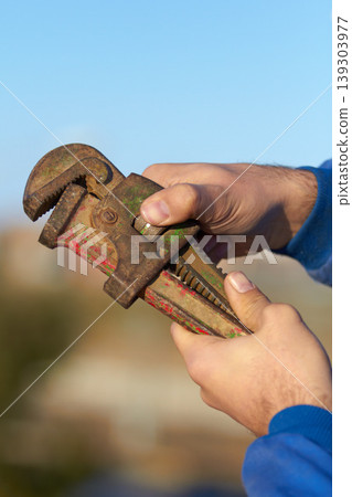 Hand, mechanic and wrench tool closeup for maintenance or repair, helping or hardware. Man, spanner and engineer for car service job or improvement for fixing at garage, steel workshop for automobile 139303977