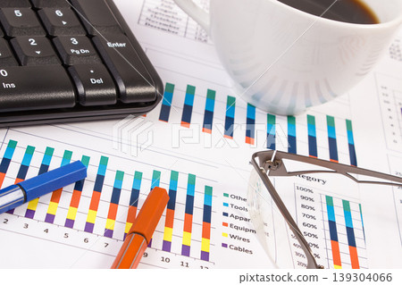Cup of coffee, ballpen, computer keyboard and financial chart  139304066