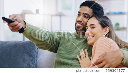 Couple, watching tv and remote on living room sofa with smile, hug or relax with click for choice, show or film. Man, woman and happy together for embrace, movie or streaming on lounge couch in home Couple, watching tv and remote on living room sofa with smile, hug or relax with click for choice, show or film. Man, woman and happy together for embrace, movie or streaming on lounge couch in home 139304177