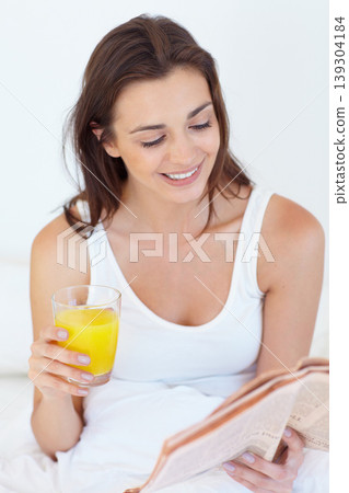 Woman in bed with juice, newspaper and smile at breakfast in hotel room on weekend holiday. Relax, orange fruit drink and happy person in bedroom reading news in morning paper on luxury vacation. Woman in bed with juice, newspaper and smile at breakfast in hotel room on weekend holiday. Relax, orange fruit drink and happy person in bedroom reading news in morning paper on luxury vacation. 139304184
