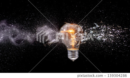Shattering light real bulb exploding with glass particles Shattering light real bulb exploding with glass particles 139304286