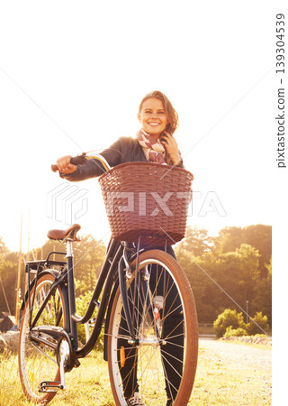 Countryside, nature and portrait of happy woman with bicycle, adventure or travel in morning. Summer, smile and bike with a basket at sunset and person in sunshine with transportation for cycling Countryside, nature and portrait of happy woman with bicycle, adventure or travel in morning. Summer, smile and bike with a basket at sunset and person in sunshine with transportation for cycling 139304539