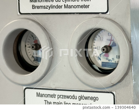 Two analog pressure gauges display readings, indicating system status and operational monitoring within industrial equipment for precise measurement 139304640