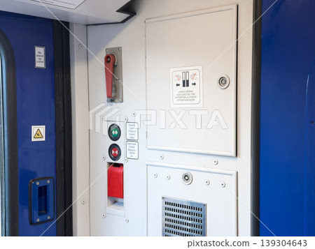 Interior view of train carriage doors with multilingual instructions and safety signage, emphasizing safe travel procedures and operational elements Interior view of train carriage doors with multilingual instructions and safety signage, emphasizing safe travel procedures and operational elements 139304643