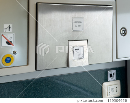 Brushed stainless steel hand dryer unit with clear signage indicating its function and intended use in a public restroom environment Brushed stainless steel hand dryer unit with clear signage indicating its function and intended use in a public restroom environment 139304656