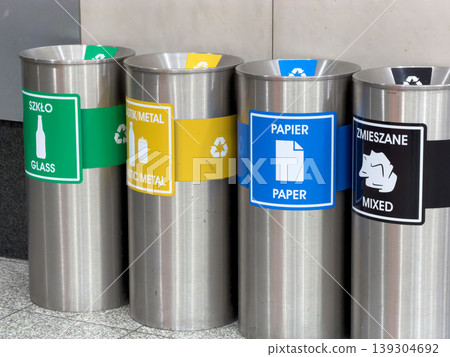 Recycling bins for different waste types are arranged in a row, promoting environmental awareness and sustainable waste management practices 139304692