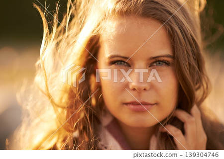 Serious, woman and portrait in nature at sunset in autumn, spring or environment in summer. Calm, face and girl relax with hair in the wind with golden, sunshine and light at sunrise in morning Serious, woman and portrait in nature at sunset in autumn, spring or environment in summer. Calm, face and girl relax with hair in the wind with golden, sunshine and light at sunrise in morning 139304746
