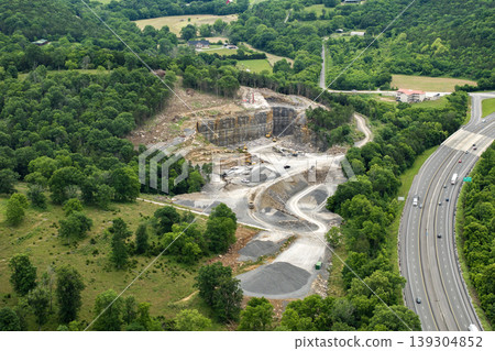Industrial open-pit mining site with limestone quarry at mountain hillside Industrial open-pit mining site with limestone quarry at mountain hillside 139304852