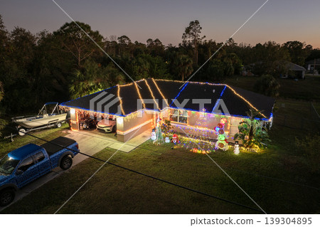 Holiday lights and outdoor Christmas decor shining brightly in front yard of a family home in Florida mild winter climate. Holiday lights and outdoor Christmas decor shining brightly in front yard of a family home in Florida mild winter climate. 139304895