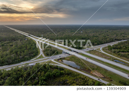 Highway intersection in Florida rural area at sunset. Elevated interchange lanes for express passing of car traffic 139304909