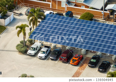 Green energy production from solar panels installed above city parking lot. Dual-purpose photovoltaic roof offering shade and renewable electricity. 139304945