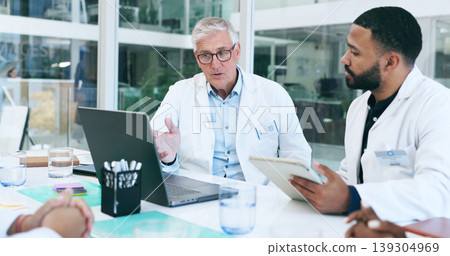 Laptop, doctor and team in meeting at hospital, discussion and planning, conversation or training. Technology, medical group and people at table in communication, healthcare and collaboration online Laptop, doctor and team in meeting at hospital, discussion and planning, conversation or training. Technology, medical group and people at table in communication, healthcare and collaboration online 139304969