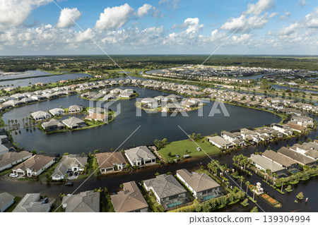 Flooding in Florida caused by tropical storm from hurricane rainfall. Suburb houses in residential community surrounded by flood waters. Aftermath of natural disaster Flooding in Florida caused by tropical storm from hurricane rainfall. Suburb houses in residential community surrounded by flood waters. Aftermath of natural disaster 139304994