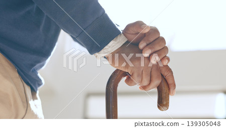 Cane, hands and senior man in home living room for retirement in house. Walking stick, closeup and elderly person with a disability, crutch for injury and support, help for health and osteoporosis 139305048