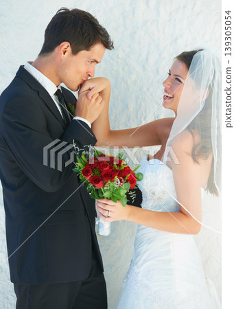 Romance, happy couple and kiss on hand at wedding with smile, bouquet and commitment at reception. Flowers, woman and man in embrace at marriage celebration with roses, loyalty and future together. Romance, happy couple and kiss on hand at wedding with smile, bouquet and commitment at reception. Flowers, woman and man in embrace at marriage celebration with roses, loyalty and future together. 139305054